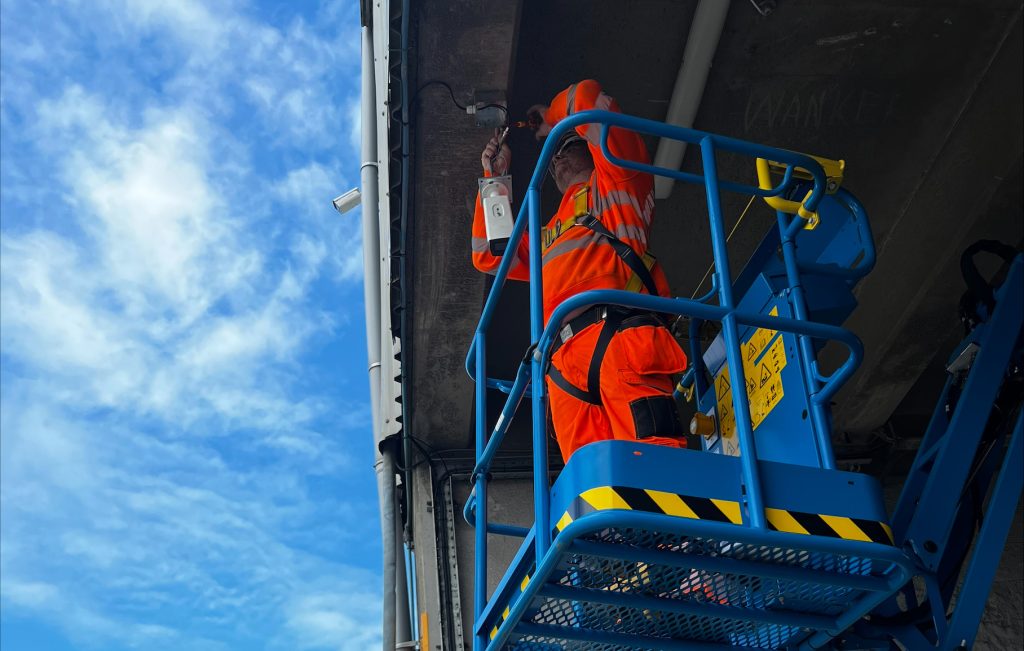a man installing a CCTV camera while stood in an aerial work platform