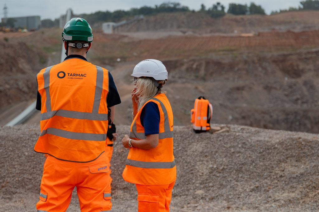 two people stood on a quarry site in hi vis